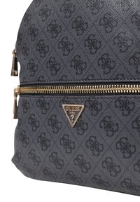 Zaino in tessuto grigio testurizzato con una zip dorata, caratterizzato da un motivo a logo in rilievo e un accento a forma di triangolo in oro.