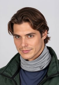 Młody mężczyzna o brązowych włosach, ubrany w szary komin na szyję i ciemnozieloną kurtkę, patrzący lekko na bok na neutralnym tle.