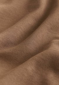 Tă fabrică maronie cu o suprafață texturată, având un aspect moale, țesut și variații subtile de nuanță. Drapaj neted și ton pământiu.