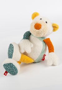 Soft plush toy bear with white, orange, and teal details. Features fuzzy texture, colorful limbs, and a tag with a red logo.