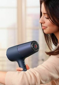 Haardroger in mat marineblauw met een rode accent. Ergonomisch ontwerp, luchtinlaatrooster met een patroonontwerp, drie bedieningselementen op de handgreep.