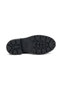 Suela de goma negra con surcos profundos para tracción, con forma redondeada y logo de la marca en relieve. Talla del modelo marcada como 37.