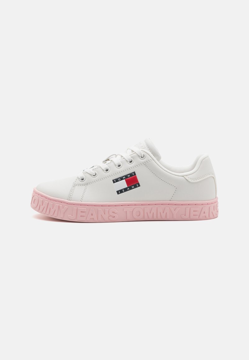 Weiße Leder-Sneaker mit einer rosa Gummisohle. Verfügt über ein rot-weiß-blaues Logo an der Seite und "TOMMY JEANS" auf der Sohle eingeprägt.
