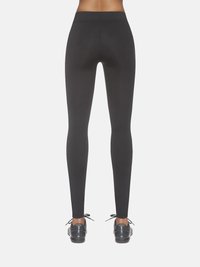 Czarne legginsy o gładkiej fakturze, z wysokim stanem i dopasowanym krojem, w zestawieniu z czarnymi trampkami z sznurówkami.