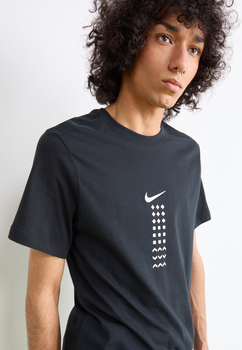 Zwarte Nike katoen T-shirt met een centraal ontwerp van geometrische vormen in het wit, ronde halslijn, korte mouwen en een regular fit.