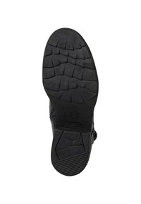 Schwarze Bootsohle mit tiefen, strukturierten Traktionsmustern; aus Gummi gefertigt, mit runder Form und Logodetails an der Ferse.