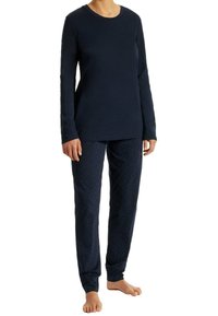 Camiseta de manga larga en color navy con escote redondo, combinada con pantalones navy que tienen un patrón de lunares. Tejido suave, corte relajado y longitud hasta los tobillos.