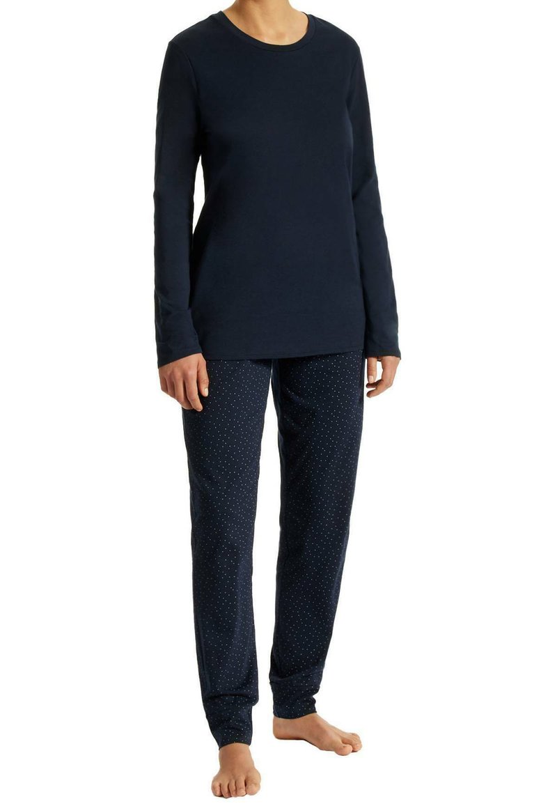 Camiseta de manga larga en color navy con escote redondo, combinada con pantalones navy que tienen un patrón de lunares. Tejido suave, corte relajado y longitud hasta los tobillos.