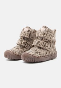Hellbraune Stiefeletten mit schwarzen Punkten, aus weichem Material, mit drei Klettverschlüssen und einer Gummisohle mit rutschfester Oberfläche.