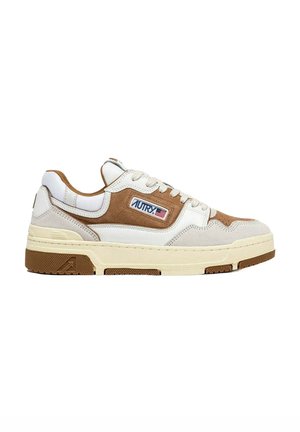 Sneakers bianche e beige con una combinazione di pelle e camoscio. Presentano una suola spessa color crema e un logo ricamato sul lato.