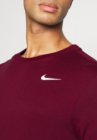 Nike Performance CREW SOLID - T-shirt desportiva - dark beetroot/white