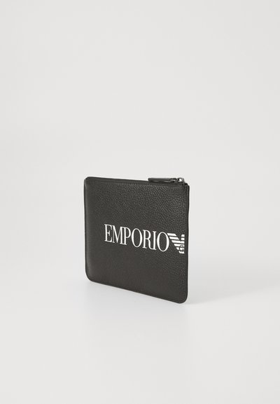 Pungă neagră din piele, cu fermoar, având logo-ul "EMPORIO" embosat în alb. Textură netedă, cu un design minimalist. Formă compactă și rectangulară.