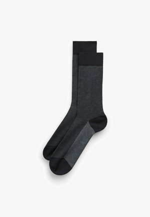 Dunkelgraue Socken mit einem strukturierten Muster, kontrastierendem schwarzen Bündchen und Zehen sowie einer glatten Oberfläche, entworfen für Komfort und Langlebigkeit.