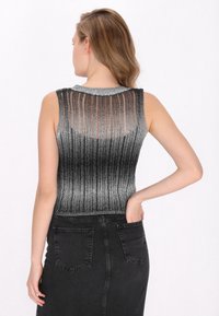 Metallisches ärmelloses Oberteil mit einem Verlauf von Silber zu Schwarz, ausgestattet mit einem strukturierten Rippendesign und einem runden Halsausschnitt.