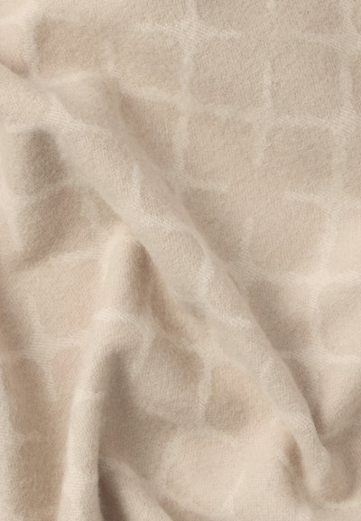 Μπεζ υφασμένο ύφασμα με διακριτικό σχέδιο καρό, που παρουσιάζει μια απαλή, ζεστή εμφάνιση και ελαφρώς ανυψωμένη επιφάνεια.