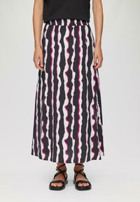 Maxi rok in zwart, wit en roze golvende strepen. Elastaanband, lichtgewicht stof en rechte snit, gecombineerd met zwarte sandaaltjes met bandjes.
