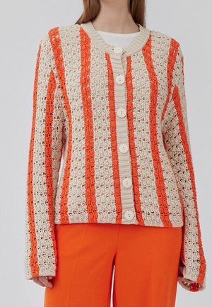 Gilet au crochet avec des rayures alternées orange et beige, doté d'un col rond et de cinq grands boutons crème sur le devant.