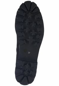 Black rubber shoe sole with deep treads, including cross and star patterns. Marked with size "37" near heel. Flat and textured surface.