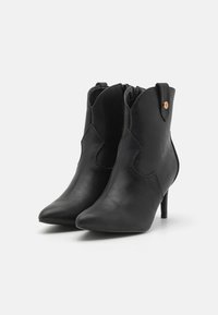 Mustad musta nahast pahkluu saapad, terava nina, sale disain ja 5 cm konts. Omab dekoratiivset külgavaust ja luku sulgemist.
