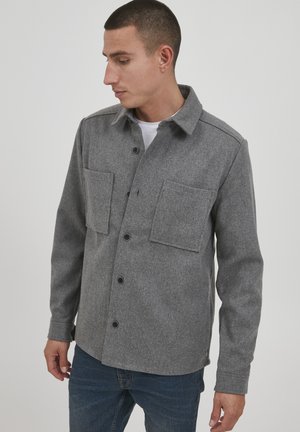 Gray wool shirt jacket with a collar, two front pockets, button closure, and long sleeves. Textured fabric with a smooth finish.