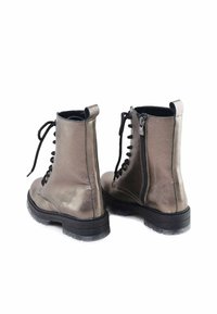 Botas de tobillo metálicas en gris con un acabado suave, que cuentan con cordones negros y un cierre lateral con cremallera, sobre una suela de goma negra texturizada.