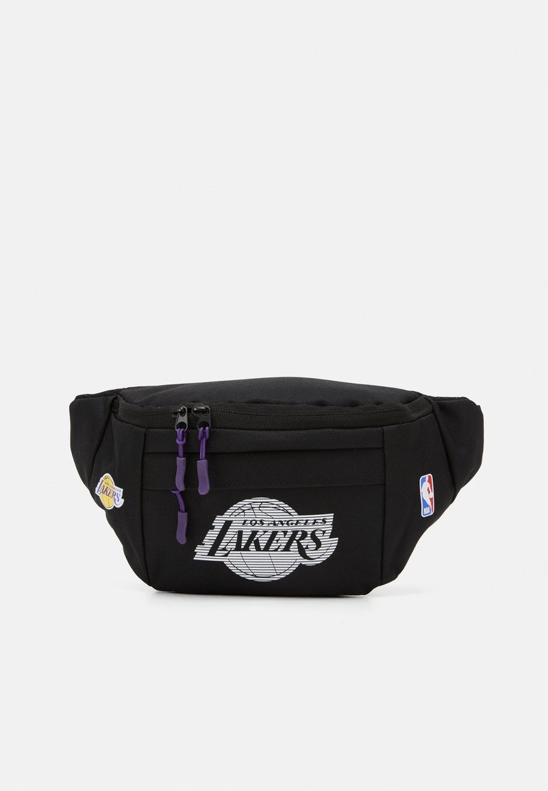 Juodas fanny pack'as su Los Angeles Lakers logotipu, baltu grafikos dizainu, purpurinėmis zipų traukėmis ir NBA logotipo pleistru. Patvari medžiaga.