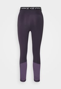 Legginsy Nike Pro w ciemnopurpurowym kolorze z jasnopurpurowymi akcentami na dolnych nogawkach. Wykonane z elastycznego materiału, z szerokim pasem w talii i logo.