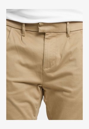 Beige trousers with a smooth texture, featuring belt loops, a straight cut, and a single front pocket detail.