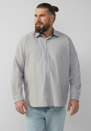 Lichtgrijs overhemd met lange mouwen en knoopsluiting, voorzien van een textuurpatroon. Heeft een klassieke kraag en wordt gecombineerd met lichtblauwe jeans.