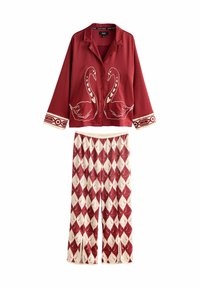 Rotes Schlafanzug-Set mit einem kurzärmeligen Hemd mit Schwanenmotiven und passenden Hosen mit rautenförmigen Mustern in Weiß und Rot. Weicher Stoff.