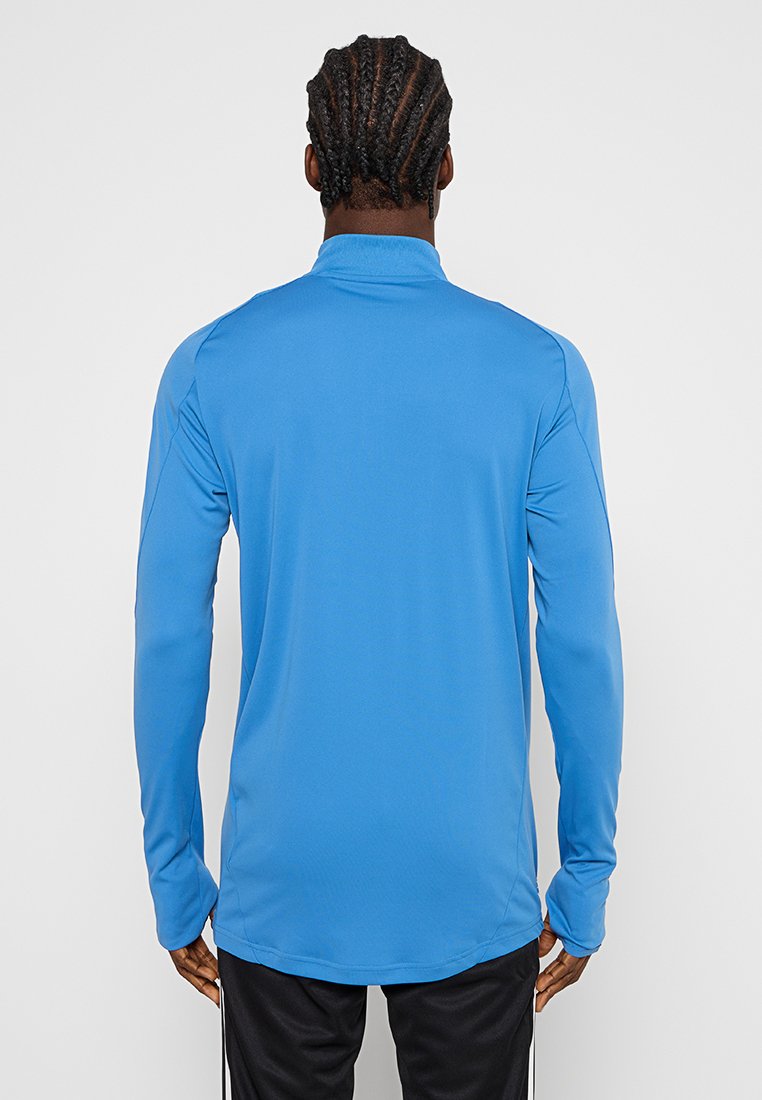 Camisa deportiva de manga larga en un azul brillante, hecha de un tejido ligero y suave. Cuenta con un cuello alto y un diseño aerodinámico y ajustado.
