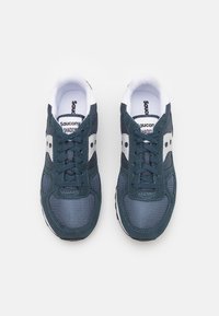 Saucony Shadow joggesko i mørkeblått, med mesh- og semsket skinnmateriale, hvite detaljer, runde lisser og et klassisk atletisk design.
