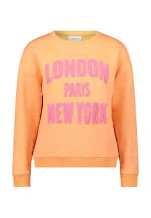 Sweatshirt orange avec un texte rose, audacieux et duveteux, indiquant "LONDRES PARIS NEW YORK" et un petit détail rose sur la manche.