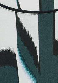 Tessuto con motivi astratti di pennellate in teal, nero e bianco. Il materiale appare morbido con una texture opaca. Bordo nero semplice.