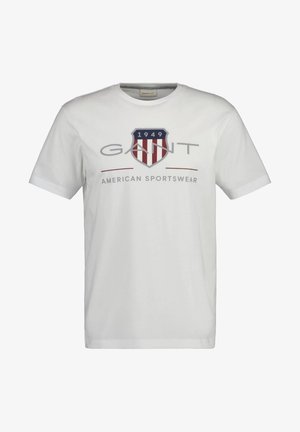 White cotton t-shirt featuring a blue and red shield logo, "GANT" printed above, with "1949" and "AMERICAN SPORTSWEAR" text below.