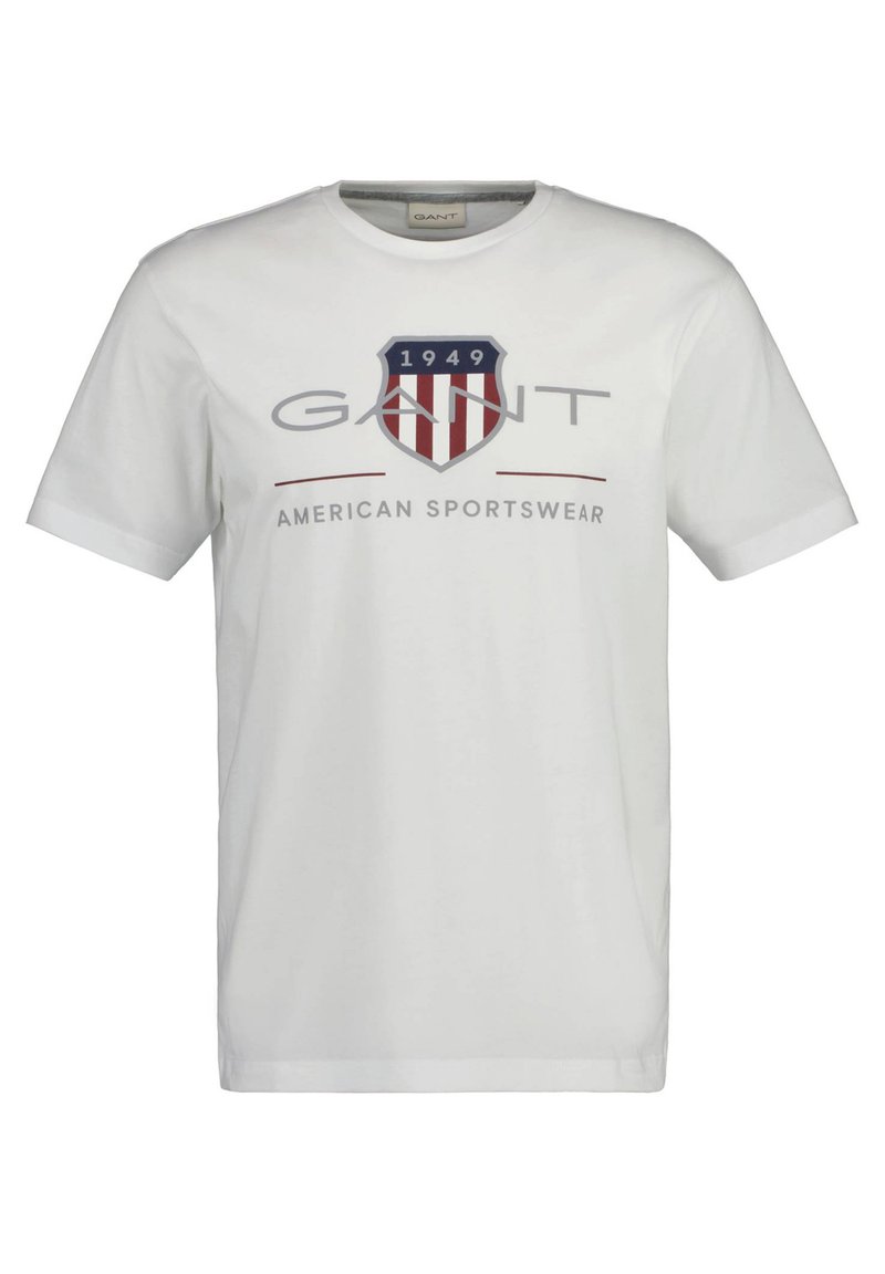 Bijela pamučna majica s plavim i crvenim štitovitim logotipom, s natpisom "GANT" iznad, a ispod s tekstom "1949" i "AMERICAN SPORTSWEAR".