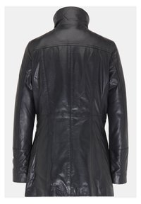 Schwarzer Lederüberrock mit hohem Kragen, auffälligen Nähdetails und tailliertem Schnitt. Die Textur ist glatt mit einem leicht glänzenden Finish.