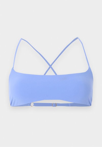 Ανοιχτό μπλε bralette με λεπτές τιράντες που διασταυρώνονται στην πλάτη και ρυθμιζόμενο λουράκι στο κάτω μέρος.