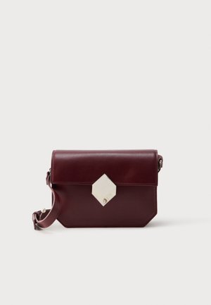 Temno rdeča usnjena torbica čez ramo z belo zaponko v obliki diamanta in nastavljivim trakom z metalno zaponko.