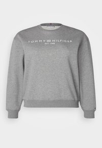 Harmaa collegepaita, joka on valmistettu puuvillasta ja jossa on pyöreä kaula-aukko, resorit hihansuissa ja helmassa, sekä valkoisella painettu teksti "TOMMY HILFIGER EST. 1985".