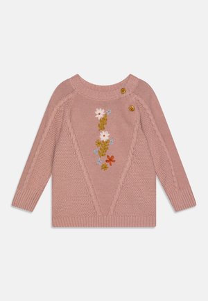 Rosa gestrickter Pullover mit floralem Stickmuster, das weißes, blaues und oranges Blumen zeigt, zwei braune Holzknöpfe an der Schulter und strukturierte Akzente.