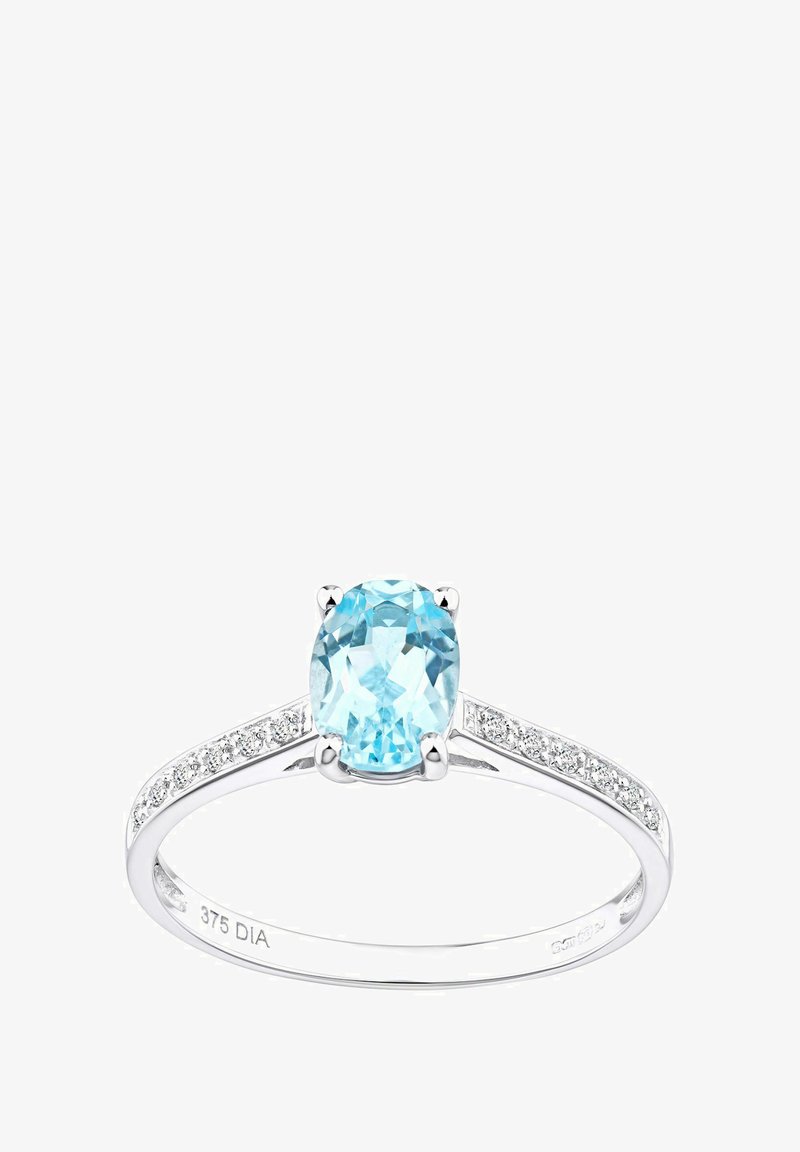 Sininen ovaalimuotoinen jalokivi hopeisessa kehykssä, jonka sivuilla on pieniä kirkaita kiviä rengasta pitkin. Silkkinen pinta ja kiillotettu viimeistely.