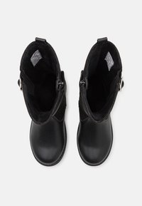 Bottes en cuir noir montant jusqu'au milieu du mollet avec fermetures éclair latérales, bouts arrondis et doublure intérieure en polaire, vues de dessus sur fond blanc.