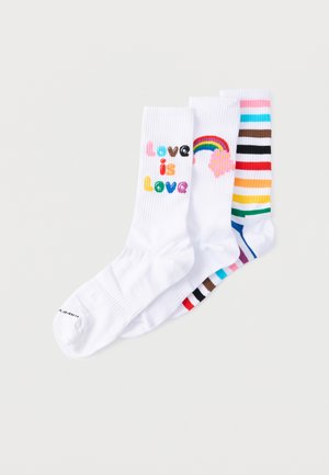 Trois chaussettes blanches pour homme côte à côte, l'une avec le texte "Love is Love" en couleurs arc-en-ciel, une avec un arc-en-ciel et un nuage, et une avec des rayures horizontales arc-en-ciel.