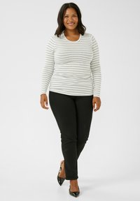 Gray and white striped long-sleeve shirt paired with black slim-fit pants. The top has a round neckline and ribbed texture. Black pointed-toe shoes.