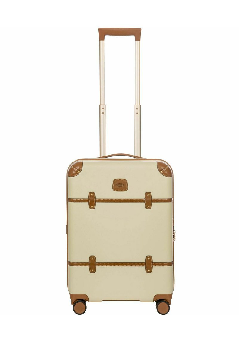 Maleta crema con detalles marrones, asa retráctil, cuatro ruedas y correas similares a un cinturón; textura suave con forma angular.