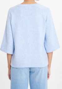 Maglione azzurro chiaro realizzato in tessuto morbido e strutturato; presenta maniche a tre quarti e scollo rotondo, con una vestibilità comoda, mostrato di spalle.