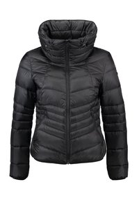 Musta puffatakki korkealla kauluksella, vaakasuoralla tikatulla kuviolla, edessä vetoketju ja sivutaskut; valmistettu kevyestä, vettä hylkivästä materiaalista.