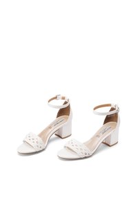 Sandali con tacco bianchi dotati di una fascetta intrecciata sulla parte anteriore, tacco a blocco, cinturino alla caviglia con fibbia e soletta liscia.