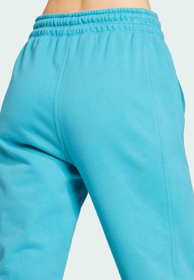 Blå sweatpants med elastisk talje, fremstillet i et blødt, textured stof og en afslappet pasform. Sidesømme og afslappede design detaljer synlige.